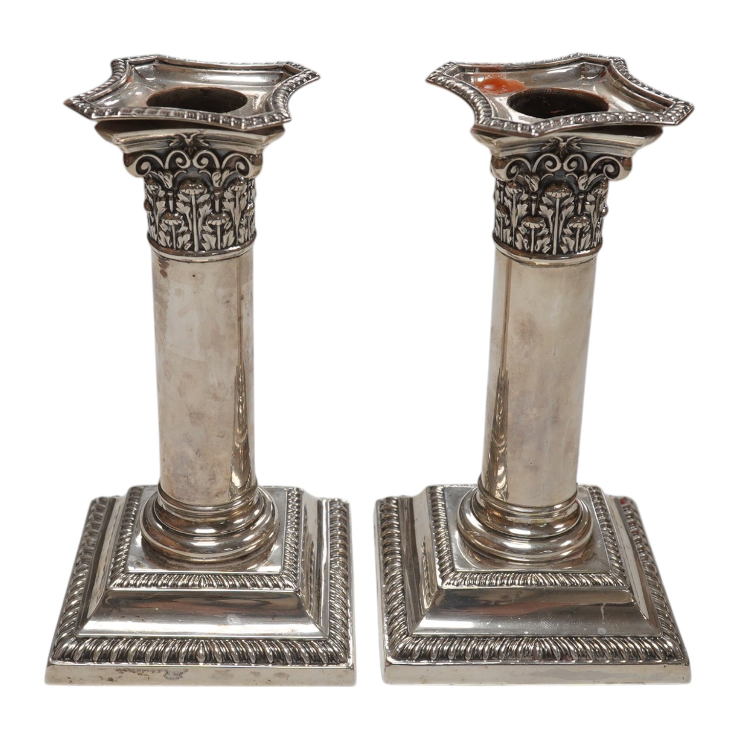 A pair of Edwardian silver dwarf candlesticks, by William Hutton & Sons, London, 1905, 14cm, weighted. Condition - fair